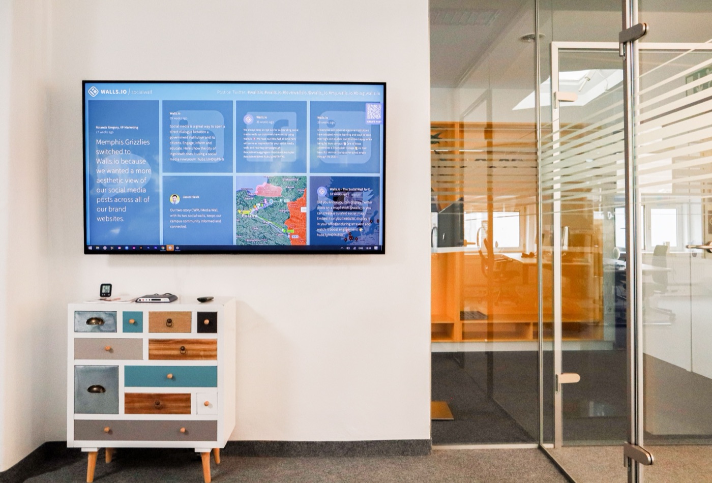 A wall-mounted dashboard showing live business metrics in an office